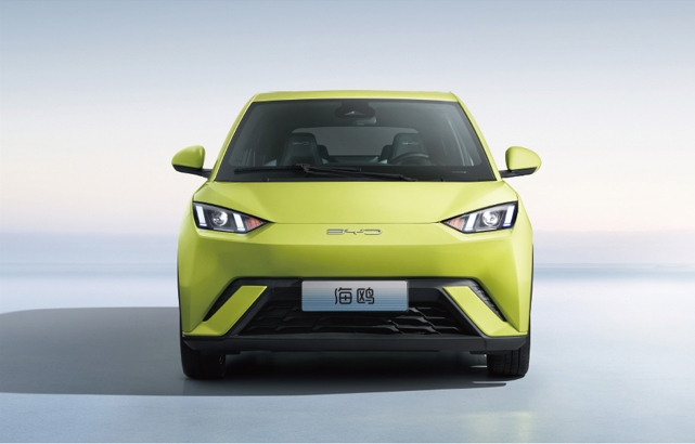 Front view of a BYD Seagull electric vehicle in bright green color, showcasing its modern design and sleek headlights against a minimalistic background.